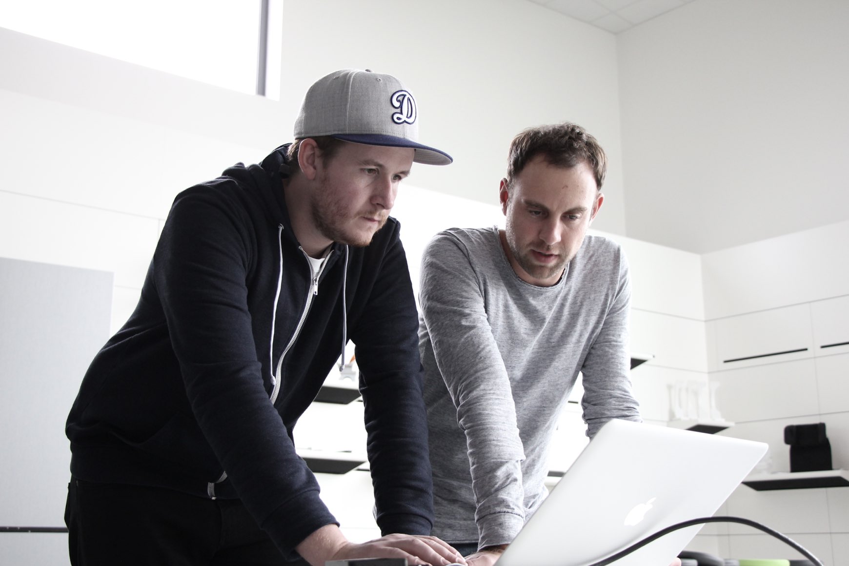 Zwei Männer schauen auf einen Laptop